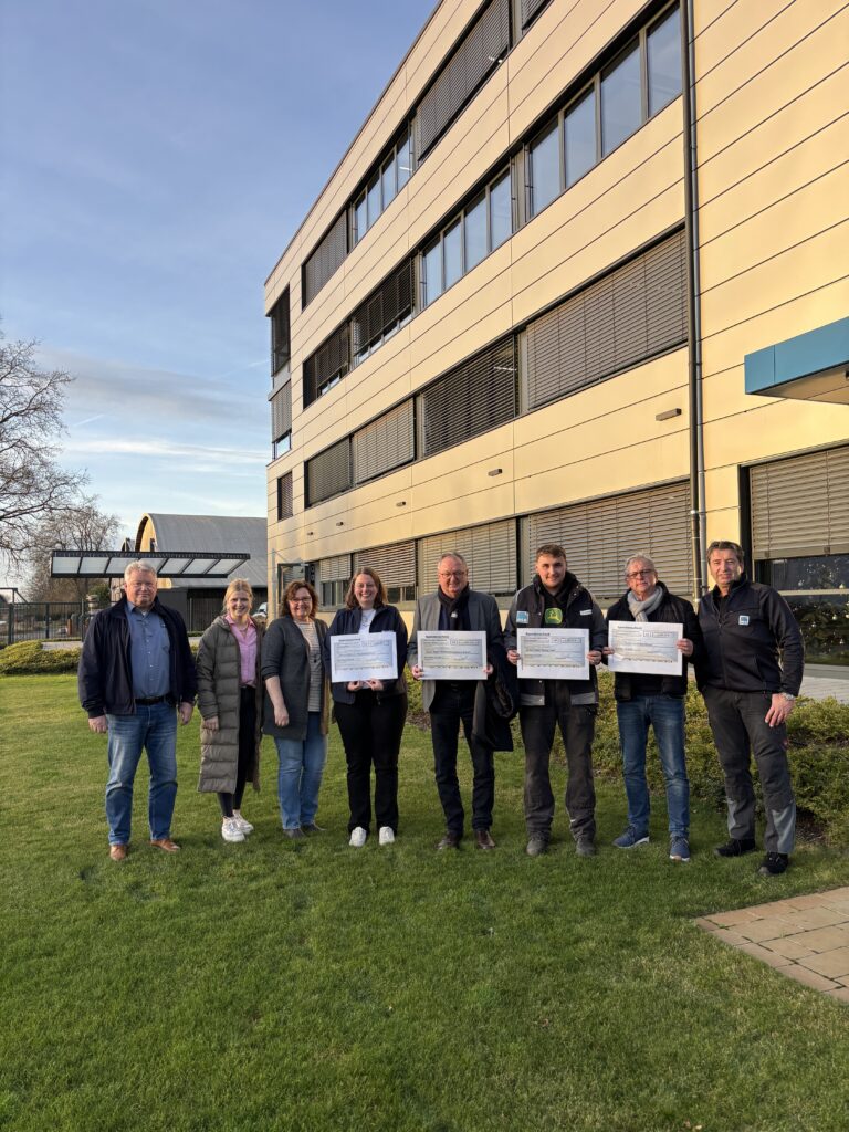 Spendenübergabe bei RSB in Rheine: Mitarbeitende und Projektvertretungen mit Spendenschecks vor dem Firmengebäude.